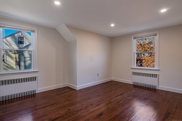 bonus room with a wealth of natural light, dark hardwood / wood-style flooring, and radiator heating unit