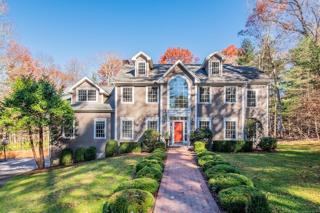 colonial-style house featuring a front lawn