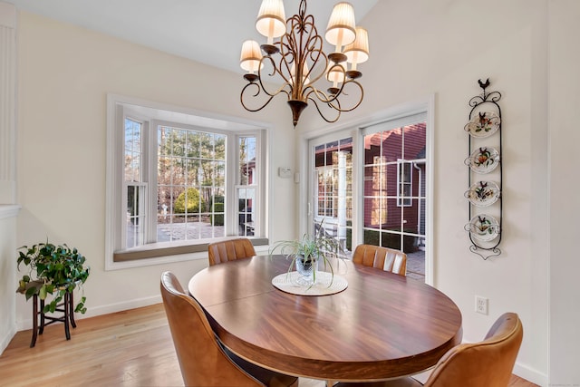 dining space with a chandelier and light hardwood / wood-style flooring