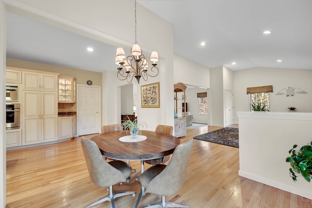 dining space featuring light hardwood / wood-style flooring, lofted ceiling, and a notable chandelier