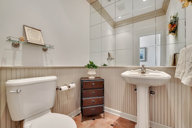 bathroom featuring crown molding, tile patterned flooring, and toilet