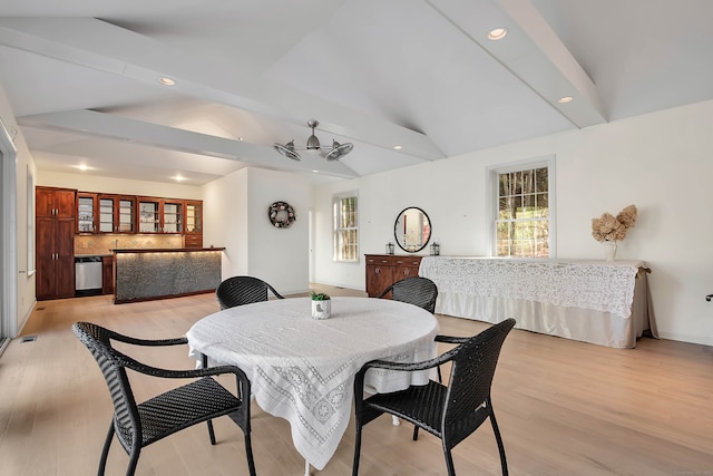 dining space featuring lofted ceiling with beams, light hardwood / wood-style floors, and ceiling fan