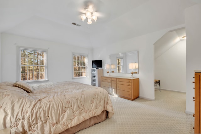 bedroom with ceiling fan, light colored carpet, and vaulted ceiling