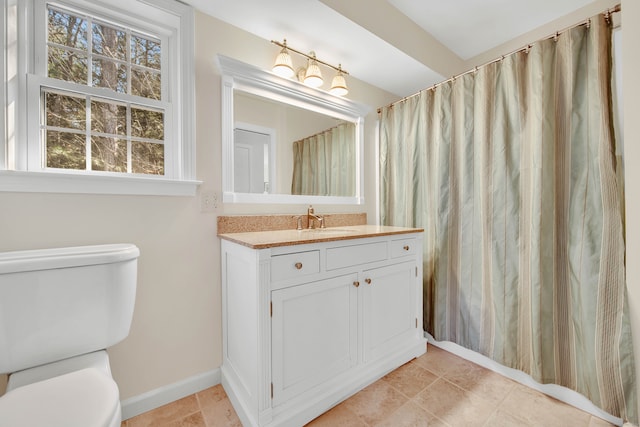 bathroom with tile patterned flooring, vanity, and toilet