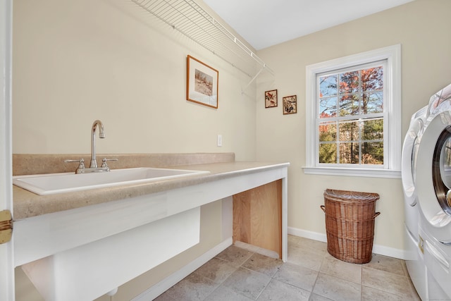 clothes washing area featuring washer and dryer, light tile patterned floors, and sink