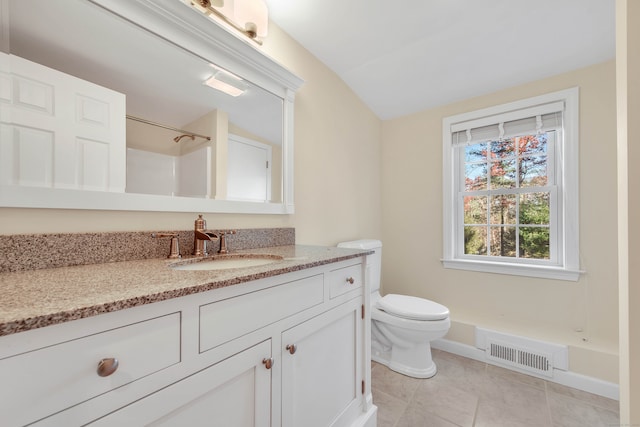 bathroom with vanity, vaulted ceiling, a shower, tile patterned flooring, and toilet