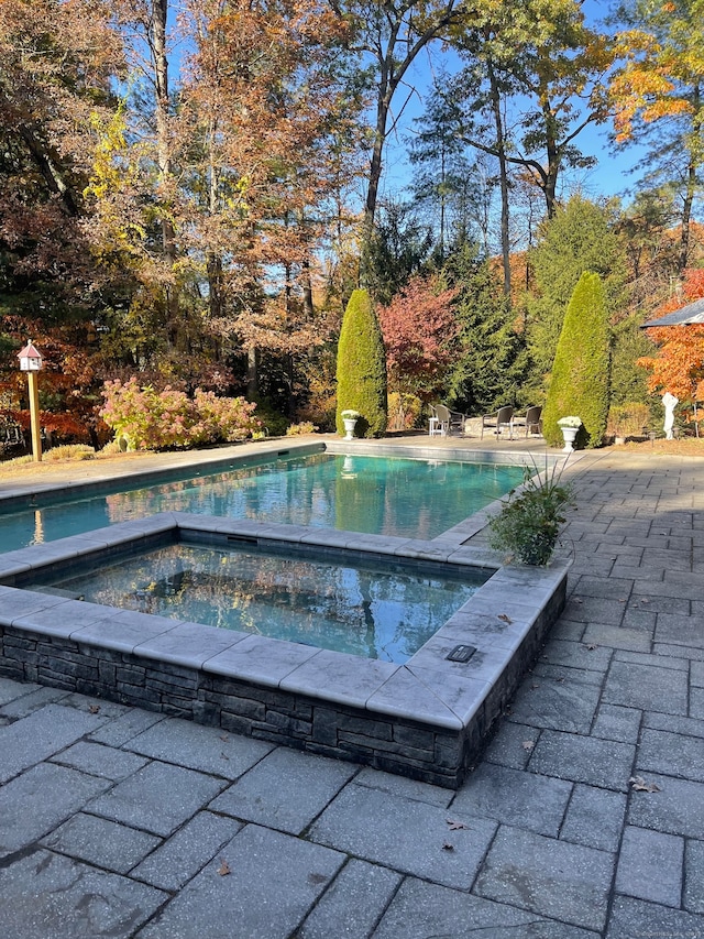 view of pool featuring an in ground hot tub and a patio