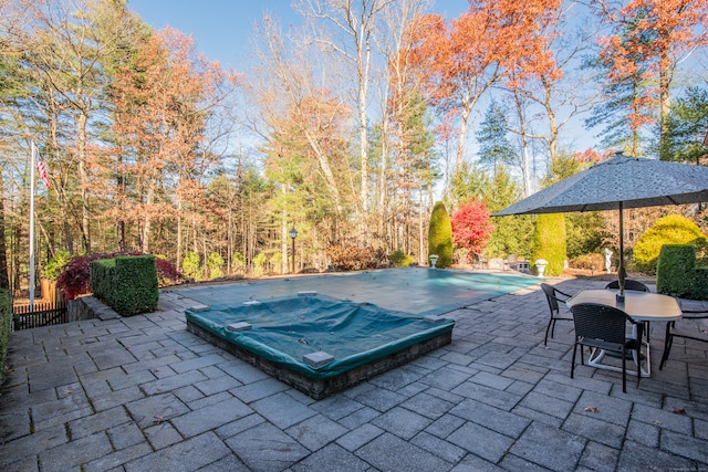 view of patio featuring a swimming pool with hot tub