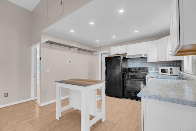 kitchen featuring backsplash, black appliances, sink, light hardwood / wood-style floors, and white cabinetry