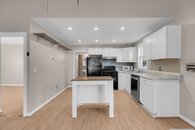 kitchen with sink, light hardwood / wood-style flooring, white cabinetry, and black appliances