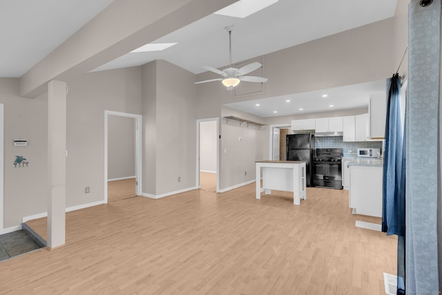 unfurnished living room with a skylight, ceiling fan, high vaulted ceiling, and light wood-type flooring