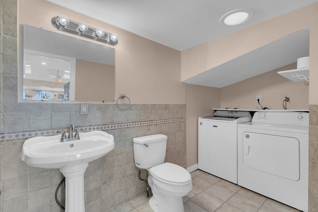 bathroom with separate washer and dryer, tile patterned flooring, and tile walls