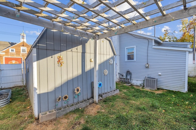 view of side of property featuring central AC unit, a pergola, and a yard