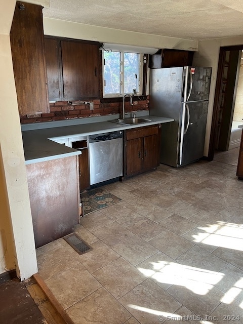 kitchen featuring sink, dark brown cabinets, and stainless steel appliances