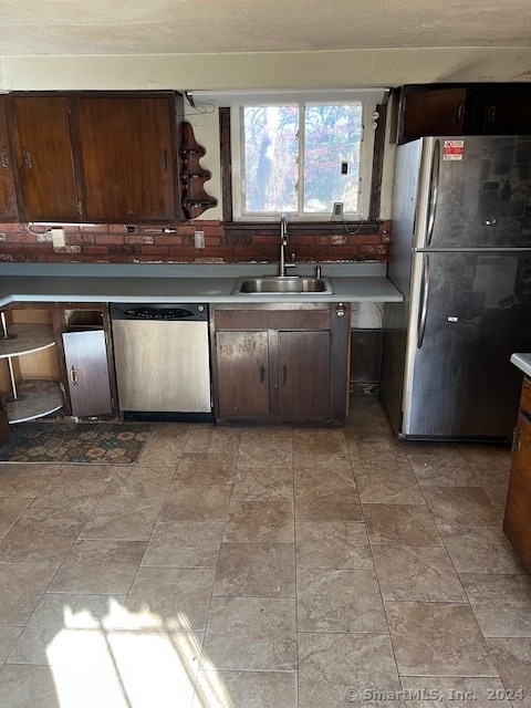 kitchen with stainless steel appliances, sink, and dark brown cabinetry