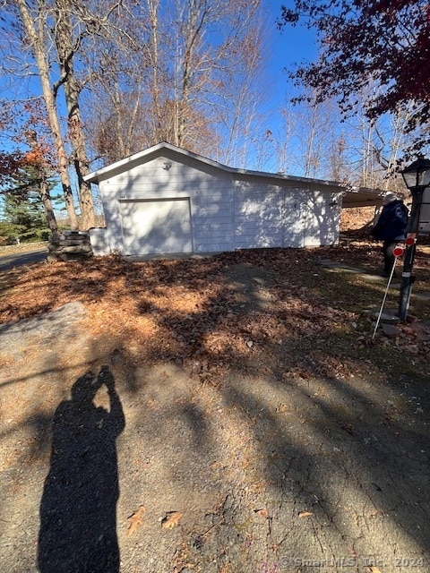 view of property exterior with a garage and an outbuilding