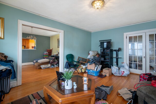 living room with hardwood / wood-style floors, ornamental molding, and french doors