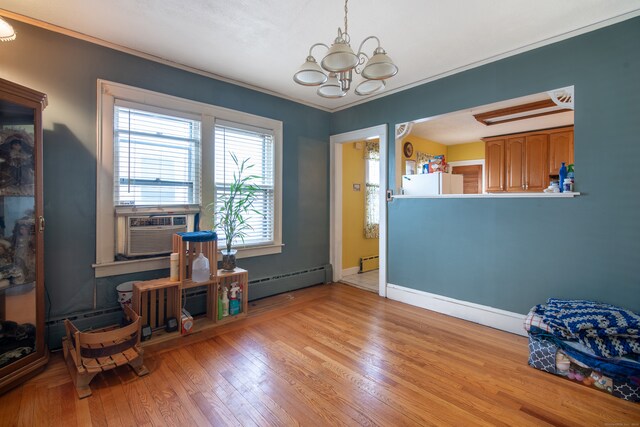 miscellaneous room with light wood-type flooring, a baseboard radiator, and an inviting chandelier