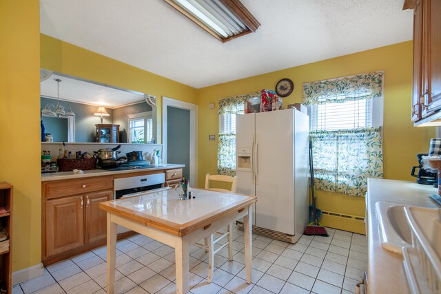 kitchen featuring ornamental molding, a baseboard radiator, white fridge with ice dispenser, and light tile patterned floors