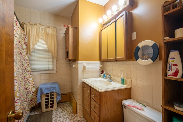 bathroom featuring toilet, vanity, tile walls, and tile patterned flooring