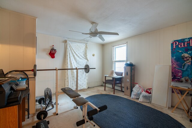 exercise room featuring a baseboard heating unit and ceiling fan
