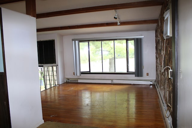 empty room featuring baseboard heating, beamed ceiling, and hardwood / wood-style flooring