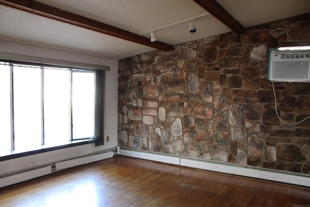 empty room with a baseboard radiator, hardwood / wood-style flooring, beam ceiling, and a wall mounted air conditioner