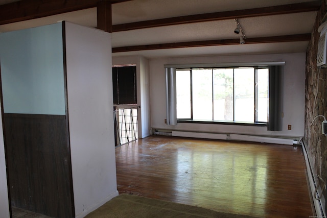 unfurnished room featuring beamed ceiling, hardwood / wood-style flooring, and a baseboard heating unit