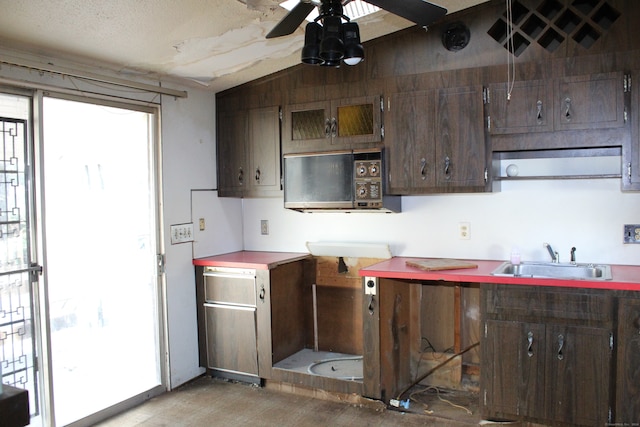 kitchen featuring ceiling fan, dark brown cabinets, sink, and vaulted ceiling