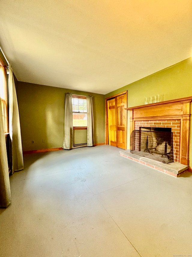 unfurnished living room with concrete flooring and a brick fireplace