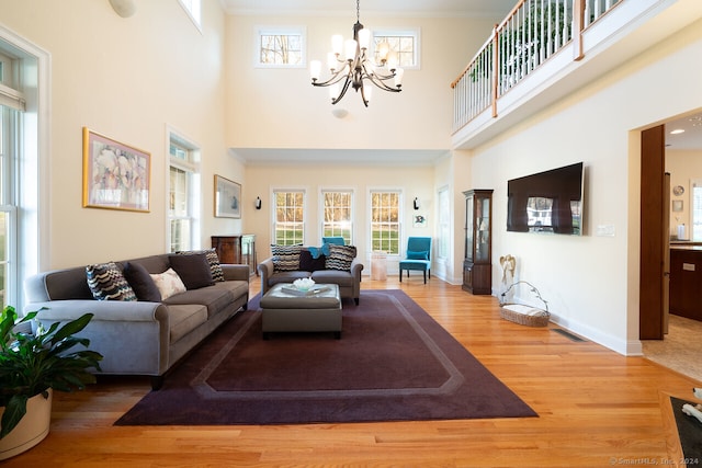 living room with a high ceiling, hardwood / wood-style floors, and plenty of natural light