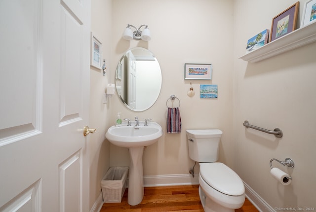 bathroom with hardwood / wood-style floors and toilet