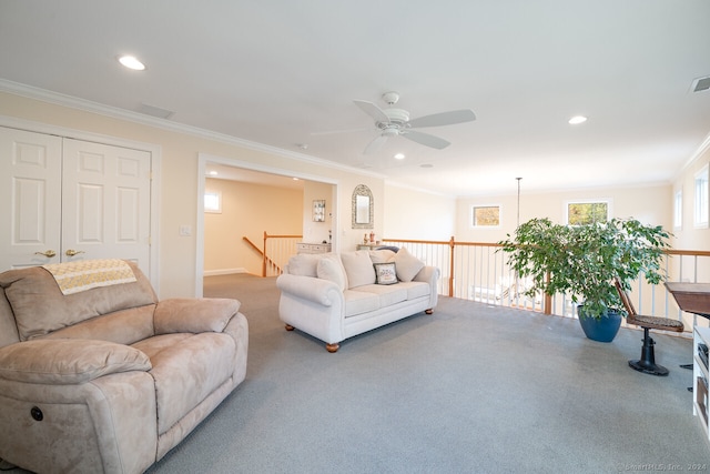 carpeted living room featuring ornamental molding and ceiling fan