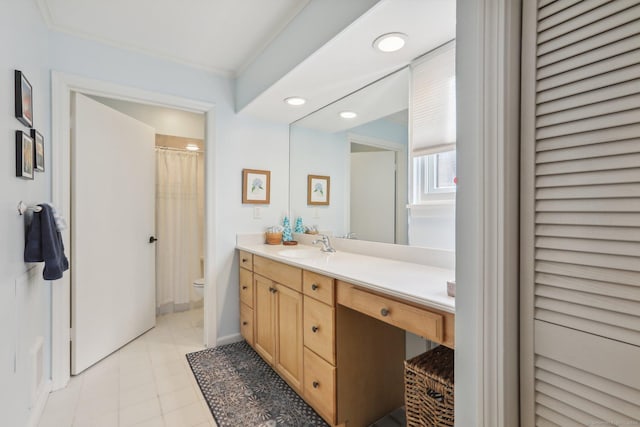 bathroom with tile patterned floors, vanity, toilet, and ornamental molding