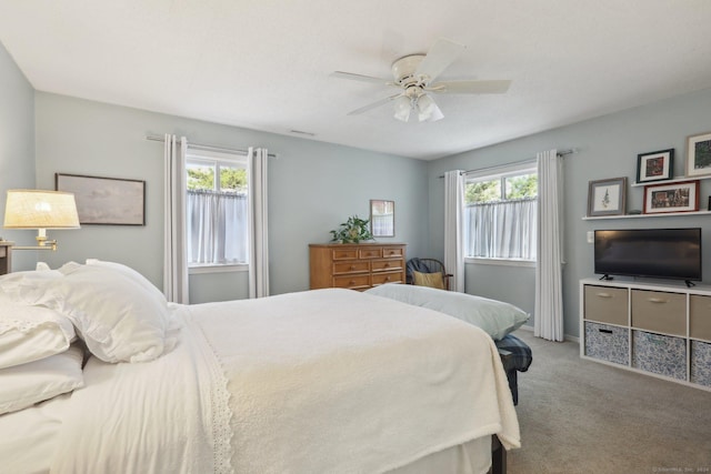 bedroom featuring multiple windows, ceiling fan, and light carpet