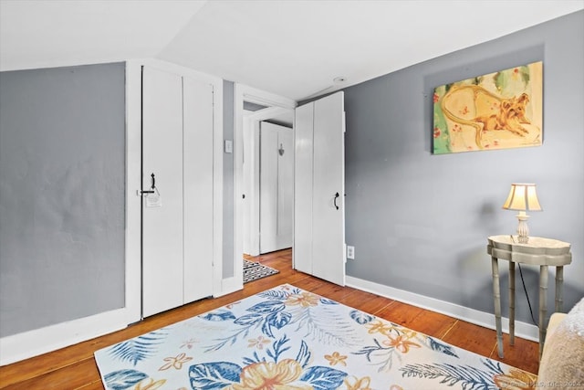 bedroom with hardwood / wood-style floors and vaulted ceiling