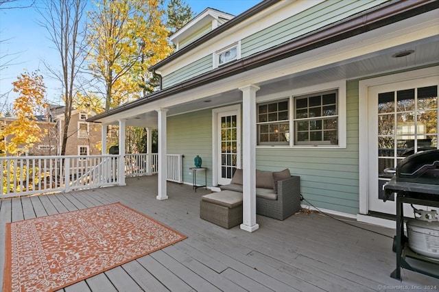 wooden terrace featuring an outdoor living space and area for grilling