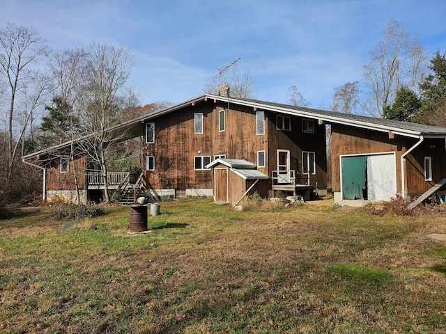 back of house with a wooden deck and a yard