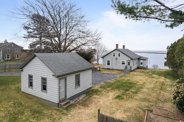 exterior space featuring a lawn and a water view