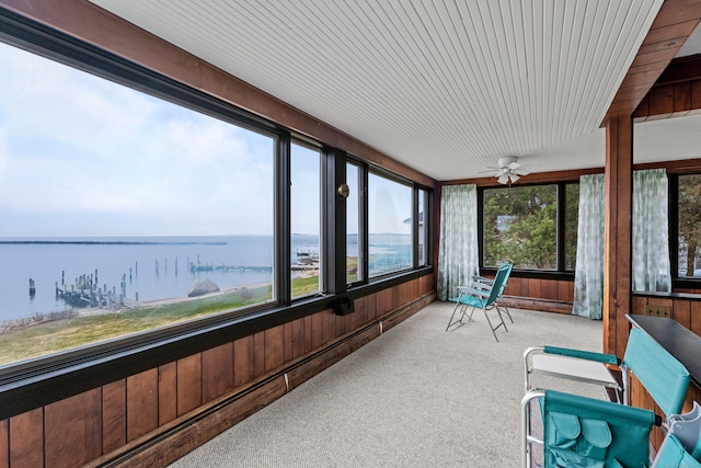 sunroom featuring a water view and ceiling fan