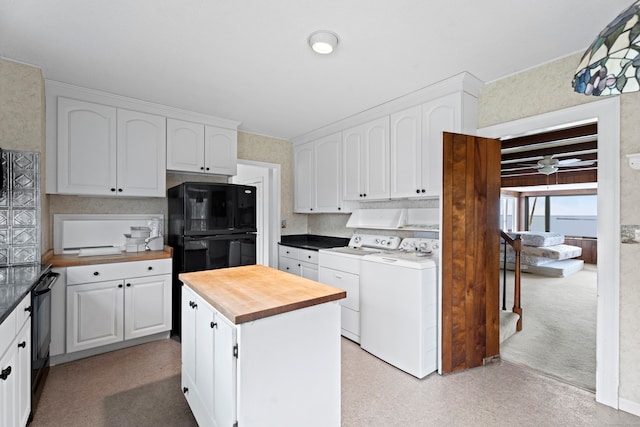 kitchen with a center island, black appliances, washer and dryer, butcher block countertops, and white cabinetry