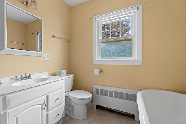 bathroom with radiator heating unit, vanity, toilet, and a tub