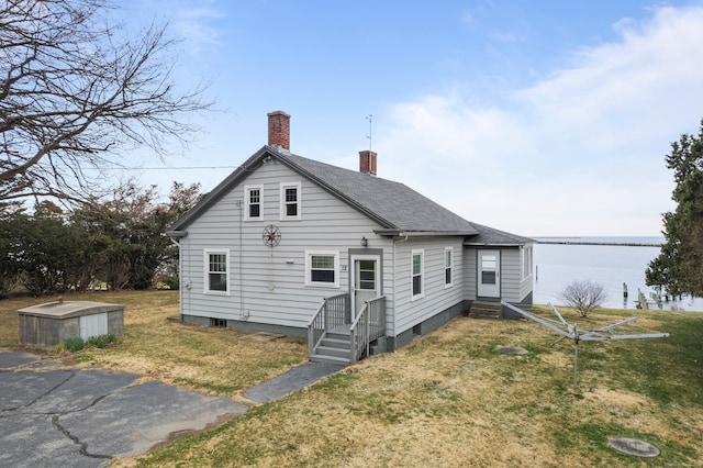 rear view of house with a yard and a water view