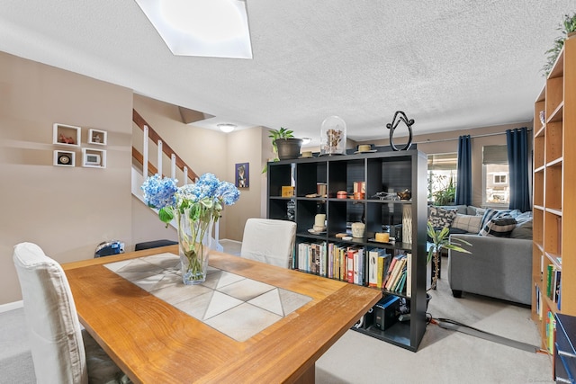 carpeted dining area featuring a textured ceiling