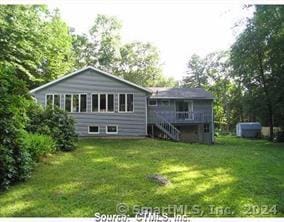 rear view of house featuring a yard