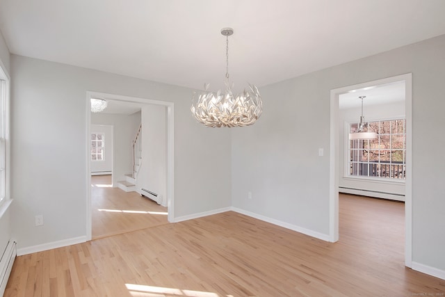 unfurnished dining area featuring a baseboard radiator and light wood-type flooring