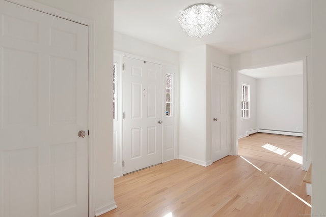 entrance foyer with a chandelier, light hardwood / wood-style floors, and baseboard heating