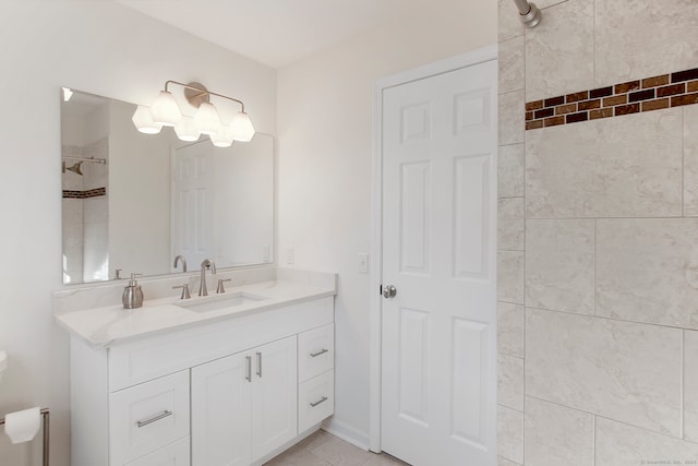 bathroom with vanity, tiled shower, and tile patterned flooring