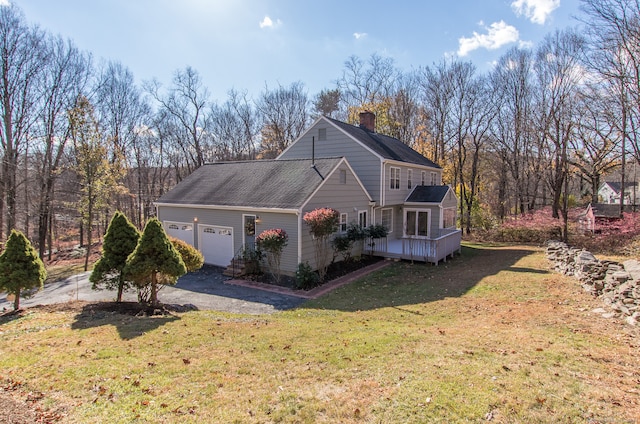 view of front property with a garage, a front lawn, and a deck