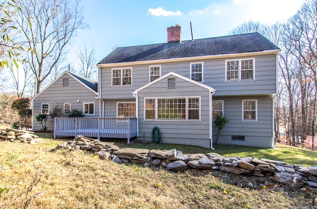 rear view of house with a deck and a lawn